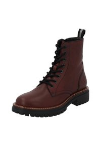 Stivale alla caviglia in pelle marrone con lacci neri, punta tonda, suola nera chunky e linguetta sul retro. Dettagli di cucitura visibili.