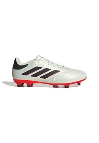 Botas de fútbol blancas con diseño de tres rayas negras, suela roja, superficie texturizada y cierre con cordones. Adecuadas para superficies de césped artificial.