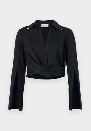 T-shirt noir court avec un décolleté en V, des boutons sur le devant et des manches longues. Présente des accents dorés sur les épaules et un design torsadé à la taille.