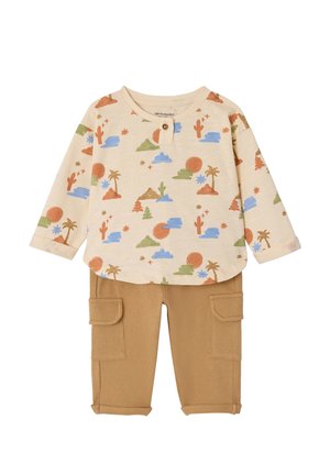 Beiges Langarmshirt für Kleinkinder mit Wüsten- und Naturmotiv, kombiniert mit hellbraunen Cargohosen mit umgeschlagenen Bündchen.
