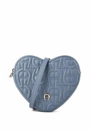 Herzförmige blaue Leder-Umhängetasche mit geprägten geometrischen Mustern und kleinem metallischem Logo auf der Vorderseite.