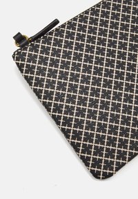 Sort-hvid lynlåspose med et struktureret geometrisk mønster. Har en rund sort knap og guld lynlåshardware.