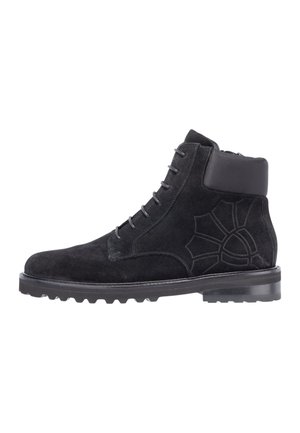 Bottine noire en daim à lacets avec col rembourré, motif latéral embossé, semelle épaisse à crampons et bout arrondi.