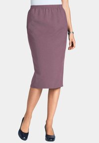 Elastischer Taillenrock in knielanger Länge aus staubigem Mauve-Stoff; elegantes Design mit glatter Textur. Getragen mit navyblauen Absätzen.