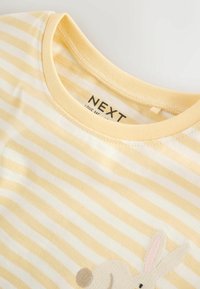 Yellow and white striped T-shirt with a round neckline and an embroidered rabbit detail on the front. Soft cotton material.