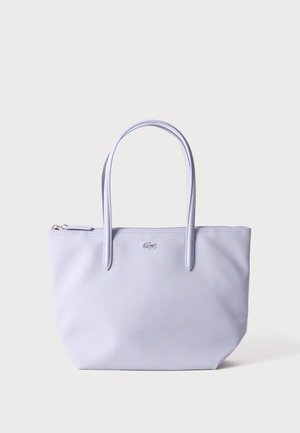 Sac fourre-tout violet clair en matériau texturé avec deux poignées robustes et une fermeture éclair, présentant un petit logo sur le devant.