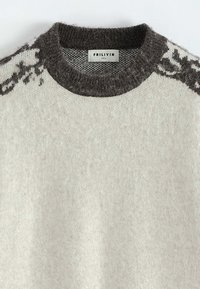 Pull en laine gris clair avec col ras du cou côtelé gris foncé et détails en motif sur les épaules, étiqueté FRILIVIN taille M.