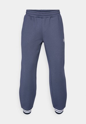 Calças de fato azul-marinho feitas de um tecido macio, com um cós elástico e punhos canelados com riscas brancas nos tornozelos; padrão texturizado subtil.