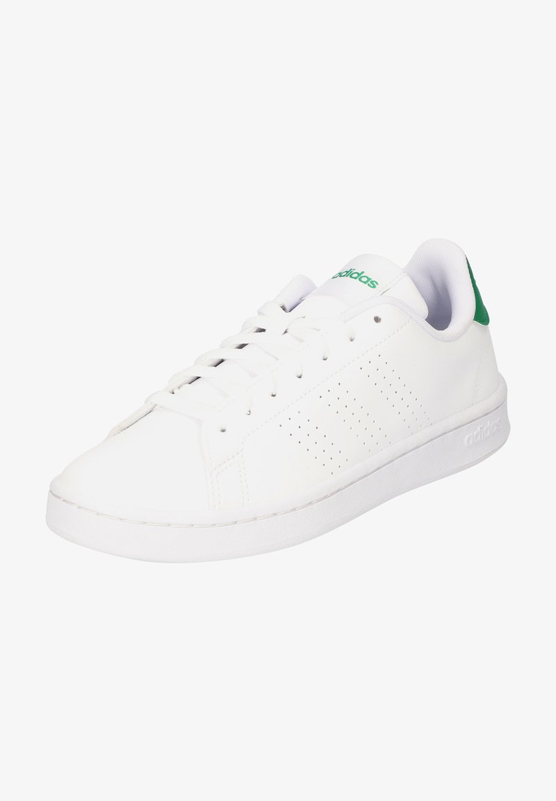 Zapatilla de cuero blanca con acento verde en el talón, con diseño perforado en los costados, cordones blancos y suela plana de goma blanca.