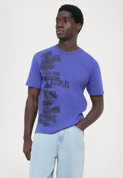 Purple cotton t-shirt featuring black text in various orientations, with distinct words like "love" and "underground." Simple crew neck design.