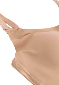 Φωτεινό ροδακινί σουτιέν με απαλό ύφασμα, ρυθμιζόμενες τιράντες και απρόσκοπτο σχέδιο. Διαθέτει διακριτικό ράψιμο και μαλακή υφή.