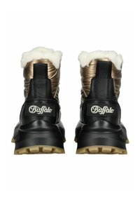 Botines negros y dorados con una textura acolchada, forro de piel sintética y una suela gruesa negra. Presentan una lengüeta con la marca y acentos del logotipo.