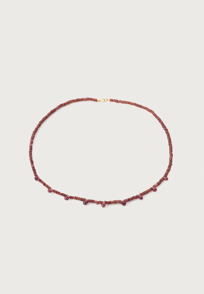 Red gemstone necklace featuring small round beads with drop-shaped accents, secured by a gold-colored clasp.