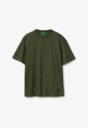 Prosty oliwkowozielony bawełniany T-shirt z krótkim rękawem, okrągłym dekoltem i małą kwadratową naszywką z logo przy dole na białym tle.