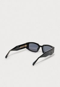 Black sunglasses with a glossy finish, rectangular lenses, and a gold-accented hinge. Slim, angular temples with a subtle pattern detail.