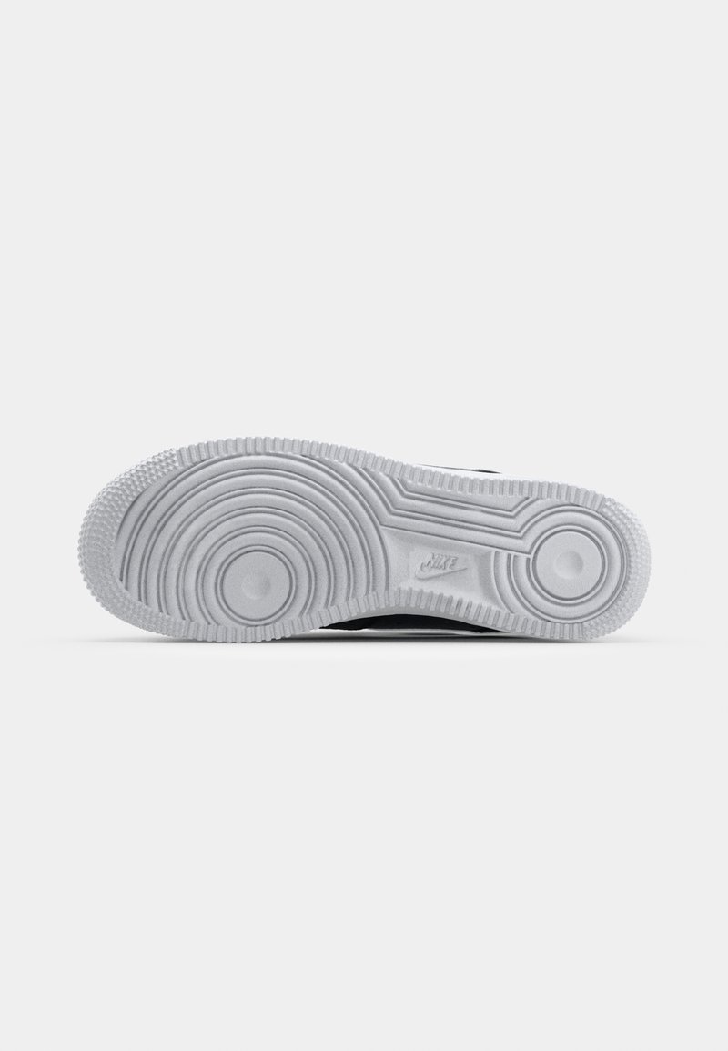 Nike-Sneaker-Sohle, weißes Gummi mit kreisförmigen Mustern, Rillen für Traktion, mit einem dezenten eingeprägten Logo. Flache Form, die für Stabilität sorgt.