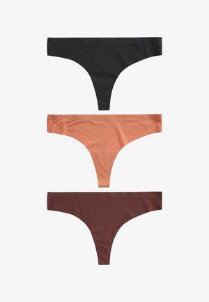 Frau trägt nahtlose dunkelbraune Bikini-Unterhose mit niedrigem Bund, Hände ruhen leicht auf den oberen Oberschenkeln, sichtbarer Oberkörper und Hüften.