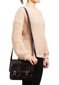 Borsa a tracolla nera in pelle con finitura lucida, patta anteriore e fibbie dorate. Texture liscia e forma rettangolare.