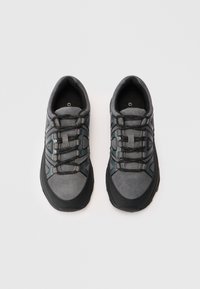 Ein Paar grau und schwarze Sportschuhe mit schwarzen Schnürsenkeln, von oben auf einem weißen Hintergrund betrachtet.
