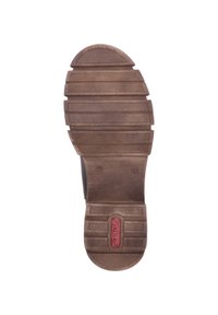 Semelle de chaussure en caoutchouc brun avec une texture antidérapante, présentant des rainures horizontales et verticales, ainsi qu'une découpe circulaire au niveau du talon. Accent logo rouge.