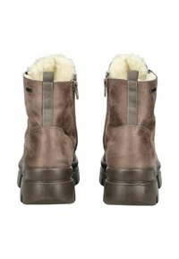 Botas de tobillo de ante marrón con forro de color crema suave, cremalleras laterales y suelas de goma gruesa y oscura. Acabado texturizado y detalles de costura.