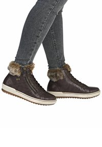 Zapatillas altas de cuero marrón con ribete de piel sintética, cremallera lateral, parte delantera con cordones y suela texturizada. Presenta una entresuela blanca en contraste.