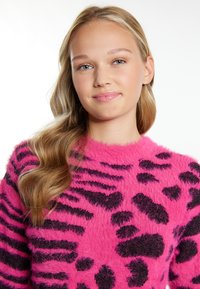 Maglione fuzzy rosa con un pattern a strisce nere e stampa animale, colletto rotondo e maniche lunghe, con una finitura morbida e testurizzata.