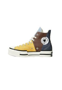Höga sneakers i gul, brun och marinblå canvas, med en vit gummisula, svarta ränder och en framträdande stjärnlogotyp.