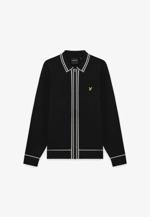 Zwarte lange mouwen sweater met ritssluiting en witte rand langs de kraag, rits, manchetten en zoom, met een klein geel vogel-logo op de linkerborst.