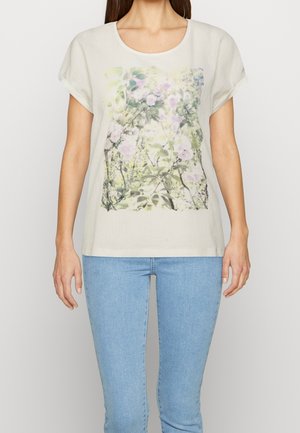 Vaaleanbeige lyhythihainen toppi, jossa on pastellivärinen kukkakuosi. Mallissa on pyöreä pääntie ja rento istuvuus.