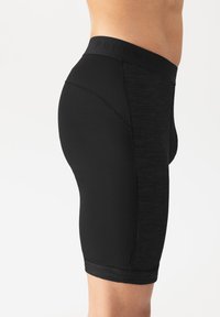 Schwarze Sportshorts aus einem glatten Material, mit einer eng anliegenden Passform, mittellanger Beininlänge und einem strukturierten Bund mit eingeprägten Buchstaben.