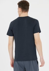 Granatowa, krótko-sleeve koszulka z miękkiego, lekkiego materiału, z klasycznym okrągłym dekoltem i luźnym krojem, wyświetlona z tyłu.