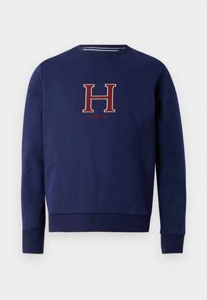 Sweatshirt bleu marine confectionné en tissu doux, avec un logo brodé rouge "H" et "Hackett" au centre, des poignets et un ourlet côtelés.