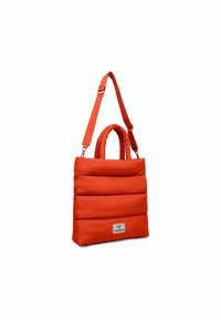 Rote gepolsterte Tragetasche mit zwei kurzen Griffen und einem langen verstellbaren Riemen, die eine rechteckige Form hat und ein Etikett auf der Vorderseite trägt.