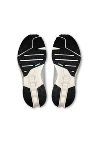 Schuhsohlen mit einer schwarzen Gummi-Außenseite, strukturiert für Traktion, verfügen über weiße und minzfarbene Akzente. Robustes Design mit klaren Rillen und Mustern.