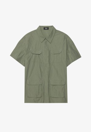 Short-sleeve, olive-green shirt made of crinkled fabric with a pointed collar, two chest pockets, and button closure.