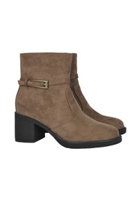 Botas de ante marrón hasta el tobillo con tacones de bloque, correa decorativa y suelas de goma negra, mostradas una al lado de la otra sobre un fondo blanco.