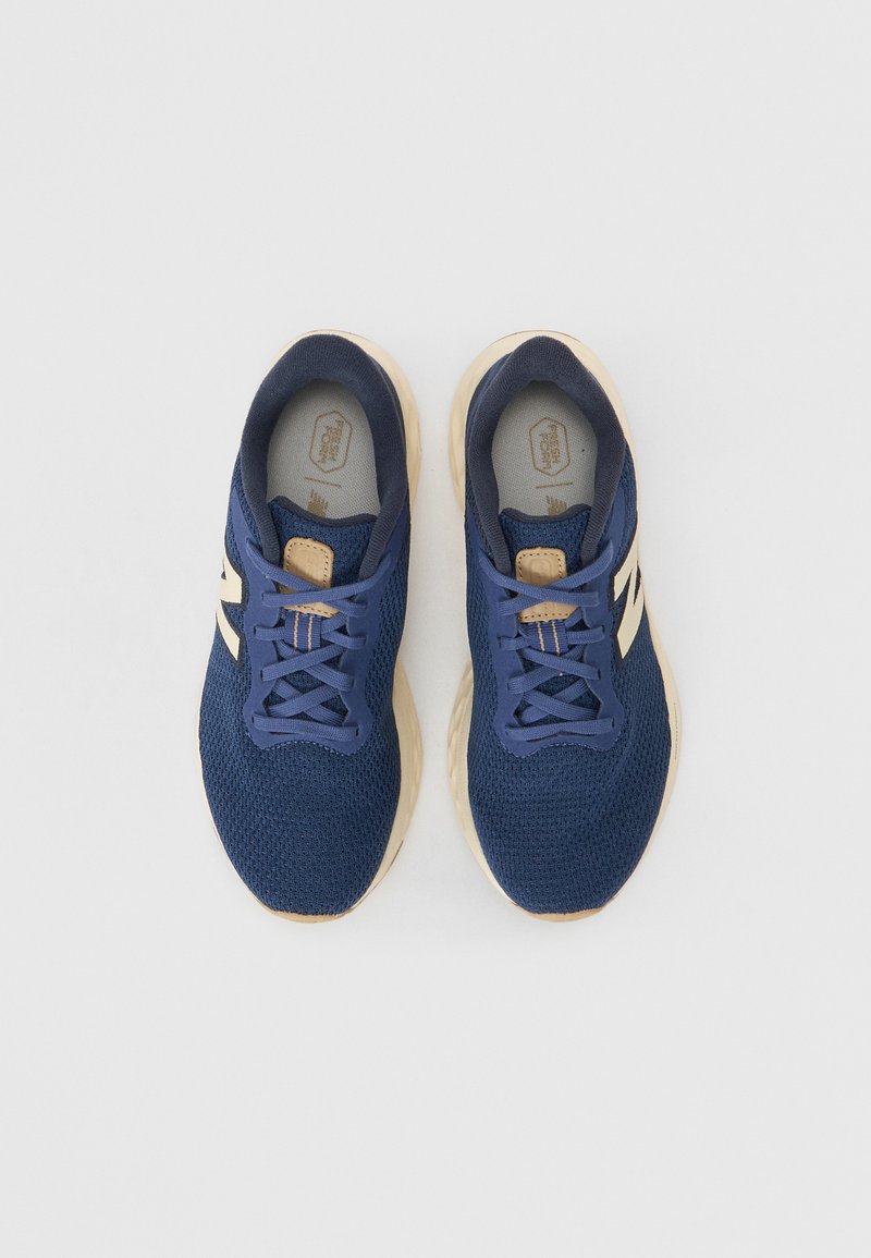 Scarpe da corsa in rete blu con accenti beige, punta tonda e design classico con lacci. Superficie testurizzata e suole interne imbottite visibili.