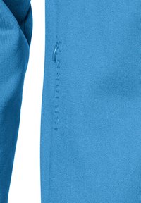 Lys blå sportsjakke lavet af glat stof, med en lynlåslomme og præget logo detaljer langs siden.