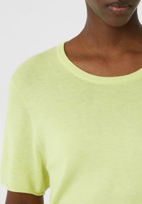 Zielona, dzianinowa, krótko-sleeve sweter w kolorze limonki z okrągłym dekoltem i gładką fakturą. Brak wzorów lub dodatkowych akcentów.