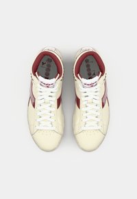 White and maroon high-top sneakers with leather material, perforated toe box, flat white laces, and textured sole. Brand logo on tongue.