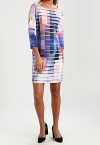 Sukienka z krótkim rękawem wyróżniająca się kolorowym, geometrycznym wzorem w różowym, niebieskim i czarnym kolorze. Wykonana z lekkiego materiału o luźnym kroju.