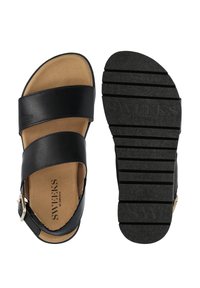 Zwarte leren sandalen met twee brede banden, een tan kleurige gevoerde binnenzool en een opvallende zwarte rubberen buitenzool met logo-imprint.