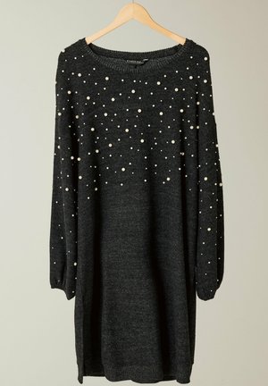 Grijze gebreide trui met lange mouwen, met verspreide witte parelaccenten en een ronde halslijn, hangend aan een houten hanger.