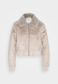 Kremowa krótka kurtka z ekoskóry z miękkim kołnierzem, przednim zamkiem błyskawicznym i ściągaczami na rękawach, posiadająca dwie boczne kieszenie.