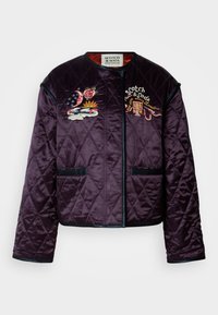 Κουβερτίνα μωβ μπουφάν με διαμαντένιο μοτίβο, κεντημένες λεπτομέρειες από λουλούδια και σύννεφα, αντίθετη μπορντούρα και δύο μπροστινές τσέπες.