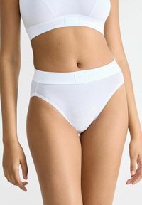 Weißer Baumwoll-Hochschnittslok mit glatter Textur, ausgestattet mit einem breiten elastischen Bund und einem dezenten Logo auf der Vorderseite.