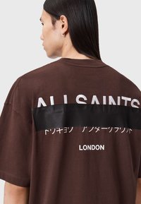 Braunes Baumwoll-T-Shirt mit weißem Aufdruck "ALLSAINTS" und "LONDON" auf der Rückseite, mit einem schwarzen horizontalen Streifen in der Mitte.
