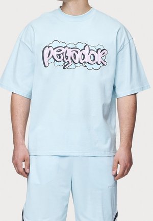 Světle modré oversized tričko z měkké bavlny s grafickým potiskem v růžové a černé barvě, který obsahuje stylizovaný text a akcenty mraků.