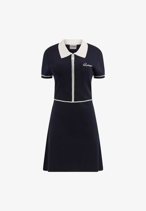 Granatowa sukienka polo z krótkimi rękawami i białym kołnierzykiem. Posiada pełny zamek z przodu, kontrastowe lamówki oraz wyszywane logo na klatce piersiowej.